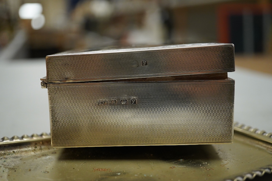 A George V engine turned silver mounted rectangular cigarette box, Birmingham, 1923, 17.7cm, a sterling mounted pepper grinder, four weighted sterling condiments and a small plated tray.